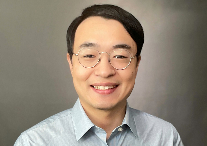 A professor smiles while posing for a headshot.