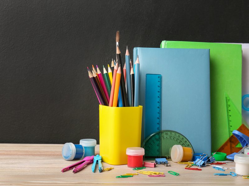 assorted colorful school supplies on a plain background