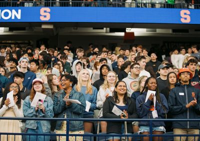large group of people standing in a stadium or arena, facing forward