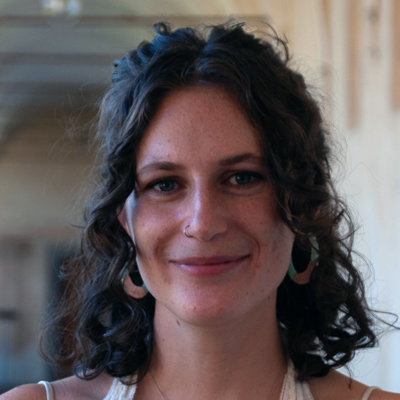 A student smiles while posing for a headshot outdoors.